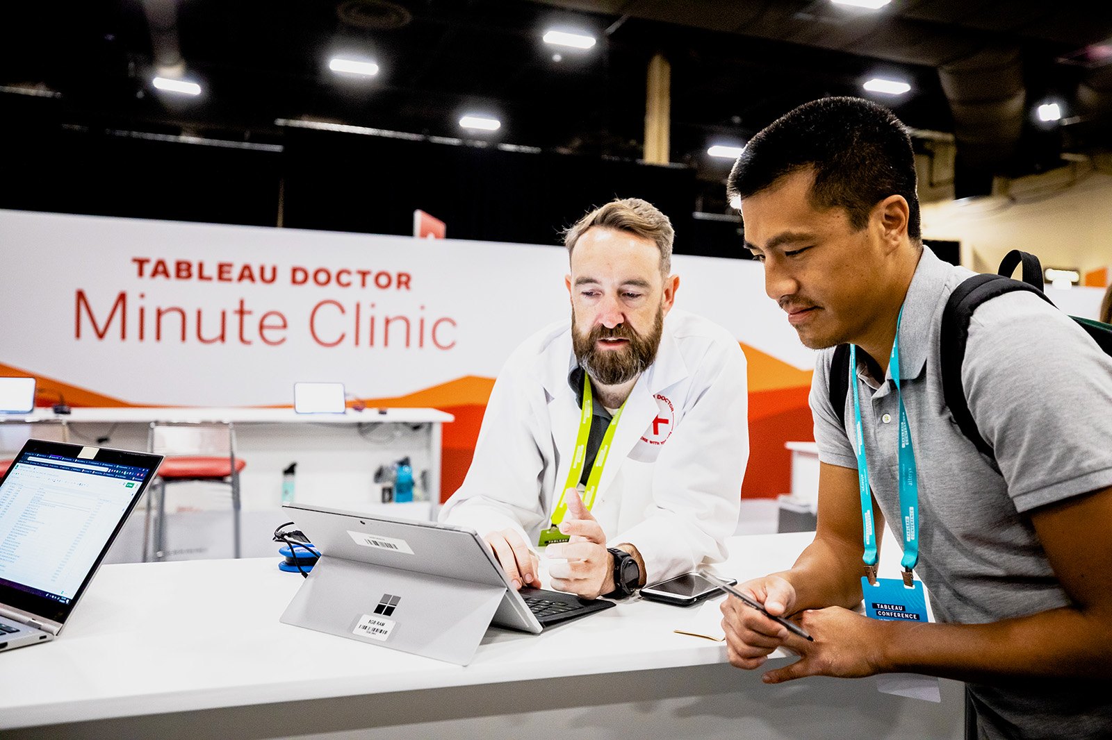 Tableau Conference in-person attendee being assisted by product expert in white lab coat